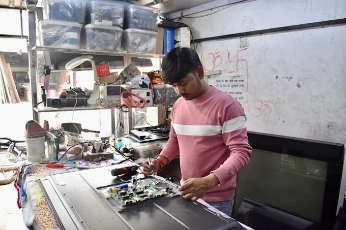 Technician repairing LED TV circuit board in Patiala workshop